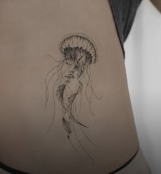 a woman's stomach with a jellyfish tattoo on it