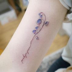 a woman's arm with flowers on it and the word love written in cursive writing