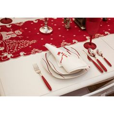 the table is set with red and white place mats, silverware, and napkins