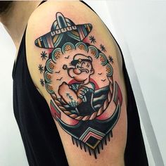 a man with a tattoo on his arm is holding an anchor in the shape of a ship