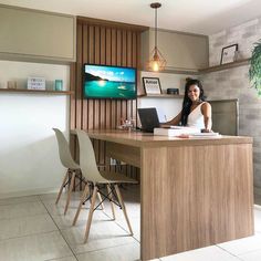 a woman sitting at a desk in front of a laptop computer on top of a wooden counter