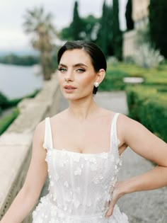 a woman in a white dress posing for the camera