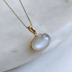 ITEM DESCRIPTION: >>The pendant is made from Solid 14K Yellow Gold. Gemstone used is absolutely natural and ethically sourced. >>Natural White Moonstones cabochon with bezel setting are studded on it with utmost precision. >>This is a minimalist design and is absolutely hassle-free and everyday jewelry. ✓ Gem: White Moonstone ✓ Gem size: 10x14 mm ✓ Gem weight: 6.98 carats ✓ Gold purity: 14K (58.33% approx.) ✓ Gold weight: 0.56 grams �✓ Gross weight: 1.96 grams The Gold purity is guaranteed and it Lapis Pendant, Handmade Jewelry Box, White Moonstone, Bezel Pendant, June Birthstone, Moonstone Jewelry, Moonstone Pendant, Unique Gemstones, June Birth Stone