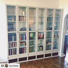 a bookcase filled with lots of books on top of a hard wood floor