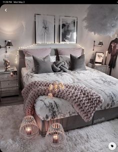 a bed with pillows and blankets on top of it in a room filled with lights