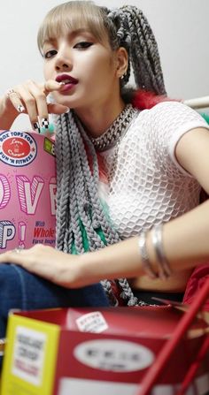 a woman sitting on top of a red chair holding a pink bag with the words lovepop written on it