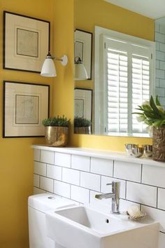 a white sink sitting under a bathroom mirror next to a wall mounted faucet