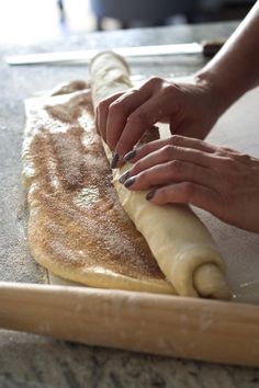 a woman rolling out dough on top of a counter