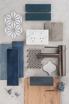 various materials are arranged on a table with white and blue accents, such as wood, tile, paper, and other items