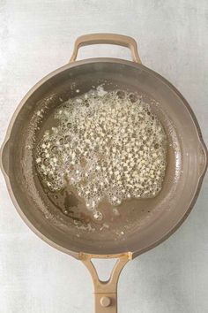 a frying pan filled with some food on top of a stove next to a wall