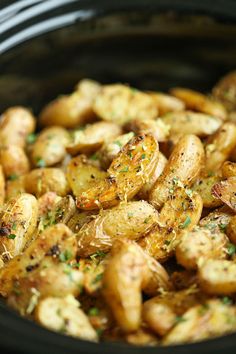 cooked potatoes with herbs and seasoning in a slow cooker