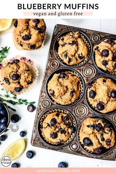 blueberry muffins in a muffin tin with lemon slices and fresh blueberries