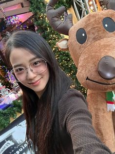 a girl is posing with a stuffed reindeer