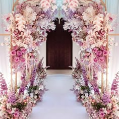 an archway decorated with purple and white flowers