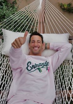 a man laying in a hammock with his thumbs up