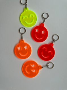 three plastic key chains with smiley faces on them