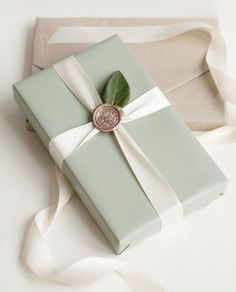 a present wrapped in green paper with a white ribbon