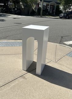 a white sculpture sitting on the side of a road