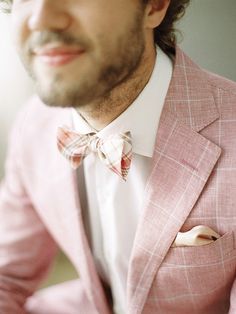 a man wearing a pink suit and bow tie