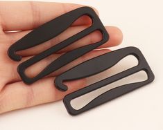 two pieces of black plastic are held in someone's hand