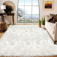 a living room with a large window and white rug