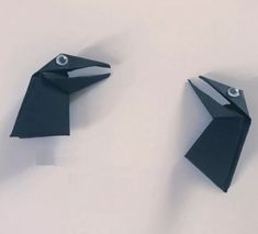 two black origami birds sitting next to each other