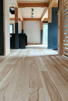 an empty room with wooden floors and black doors