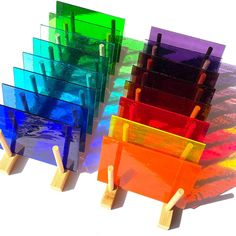 there are many different colored pieces of glass on wooden sticks in front of each other