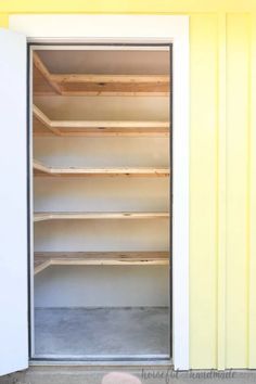 empty shelves in the corner of a room with yellow paint on the walls and floor