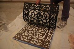 a man is working on an ornate iron screen in the process of remodeling