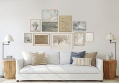 a white couch sitting in front of a wall with pictures on the wall above it