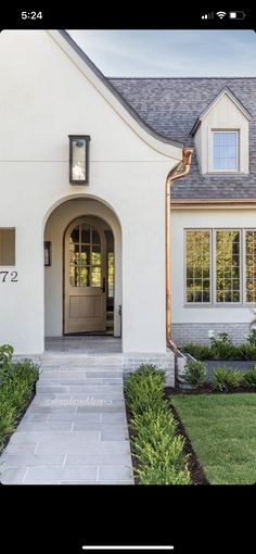 a white house with a clock on the front door and walkway leading up to it