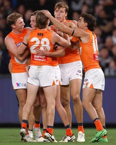 a group of men standing next to each other on top of a field