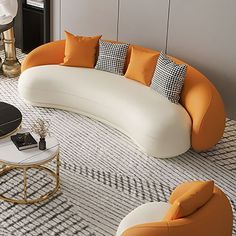 an orange and white couch sitting on top of a rug next to a coffee table