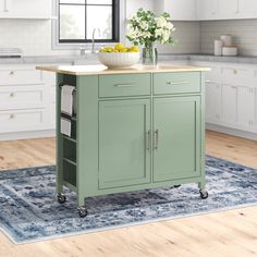 a kitchen island with a bowl of fruit on it and a rug in front of it