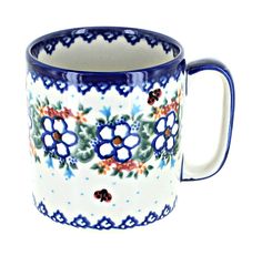 a blue and white coffee mug with flowers on the inside, sitting in front of a white background