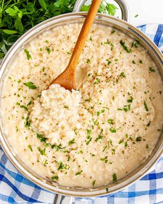 a pot filled with rice and parsley on top of a blue checkered table cloth