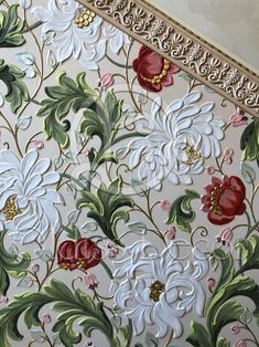 an ornate wallpaper with red, white and green flowers in gold trimmings