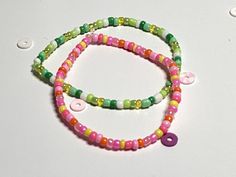 two bracelets with colorful beads and buttons on them