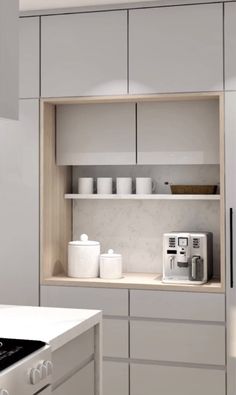 a kitchen with gray cabinets and white countertops is pictured in this image, there are cups on the shelf