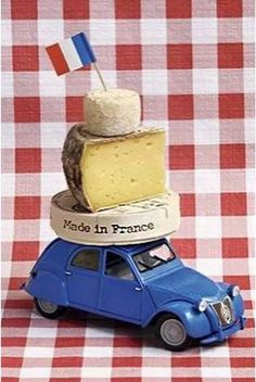 a toy car with cheese stacked on top of it and a flag sticking out of the top