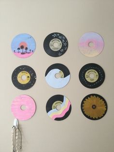 a wall mounted with different types of records and a pair of scissors hanging from it's side