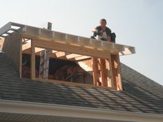 a man sitting on top of a roof