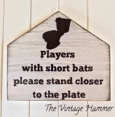 a sign that says players with short bats please stand close to the plate on a wall