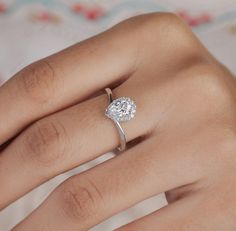 a woman's hand with a diamond ring on top of her finger and an engagement band