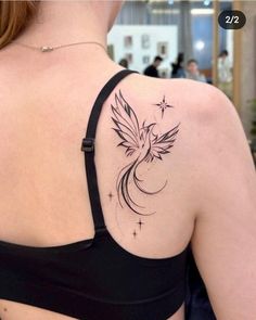 the back of a woman's shoulder with a bird and stars tattoo on it