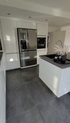 a modern kitchen with stainless steel appliances and white cabinetry is pictured in this image