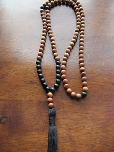 108 Bead Mala Matte Black Onyx and Sandalwood This traditional 108 bead mala features high quality fragrant sandalwood and silky matte black onyx gemstones. It is finished with a hand tied cotton tassel. A pleasure to meditate or recite mantras with. A beautiful and meaningful necklace. Black Wooden Beads For Meditation, Black Necklaces With Wooden Beads For Healing, Summer Shoot, Trendy Chokers, Delicate Choker, Mala Jewelry, Meaningful Necklace, Starburst Necklace, Diamond Choker Necklace