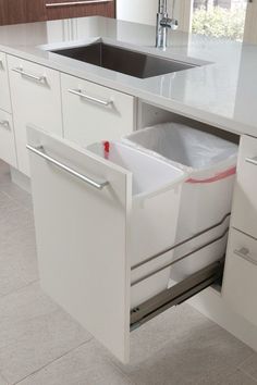 a kitchen with white cabinets and an open dishwasher