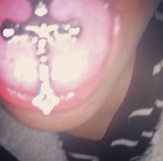 a close up of a person's tongue with a cross on it and light coming through the middle